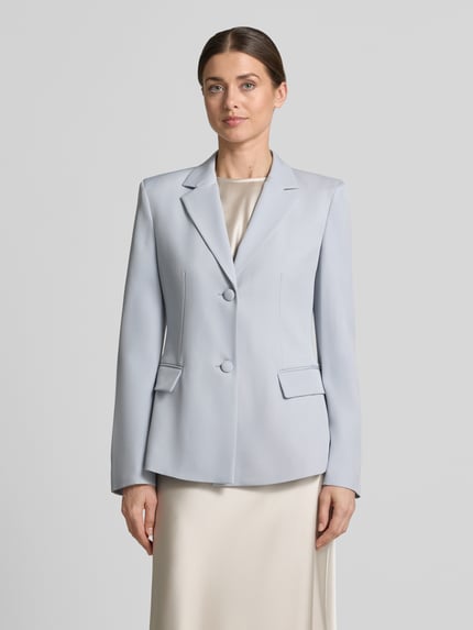 Kobiece modelka nosi Blazer mit Reverskragen und Pattentaschen von Jake*s Collection, jasnoniebieski, mieszanka materiałów z dodatkiem streczu, taliowany krój, kołnierz z połami, listwa guzikowa, kieszenie z patką, długość tyłu w rozmiarze 36: 65 cm, szerokość w rozmiarze 36: 46 cm, długość rękawów w rozmiarze 36: 63 cm, gładka faktura, widok całej sylwetki z przodu.