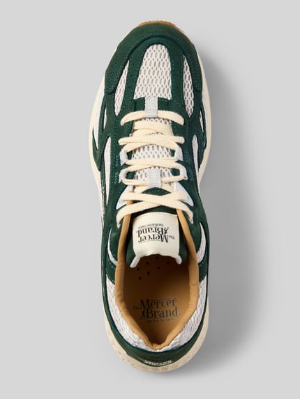 Produktfoto, Sneaker mit Kontrastbesatz von The Mercer, grün-weiße Farbakzente, strukturierte Sohle, Label-Print, Schafthöhe 8 cm, Schaftweite 11 cm, Absatzhöhe 5 cm, abgerundete Form, Schnürverschluss, Ansicht von oben.