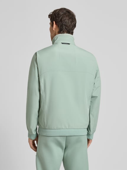 Männermodel trägt Regular Fit Funktionsjacke aus wasserdichtem Material – Porsche x BOSS, Optik: Unifarben, Ganzkörperansicht Rückansicht.