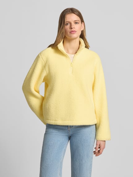 Vrouwenmodel draagt Regular Fit Pullover met opstaande kraag model 'Vera' van JJXX van teddyfleece in lichtgeel, halfhoge rits, Ganzkörperaanzicht van voren.