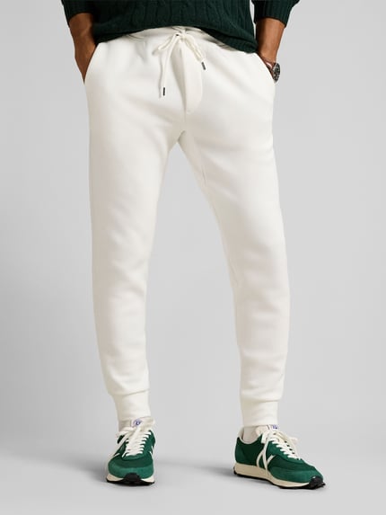 Mannenmodel draagt Tapered Sweatshorts uit katoenmix van Polo Ralph Lauren, effen design, logo-stitching, elastische tailleband, zij- en achterzakken, sweatmateriaal, voorkant volledige lichaamsopname.