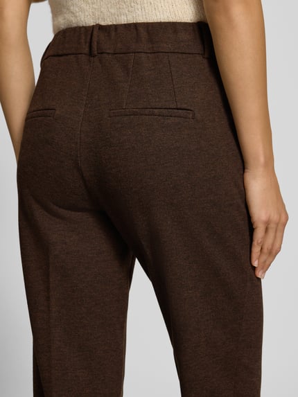 Frauenmodel trägt Regular Fit Hose mit Bügelfalte von Stehmann in Braun, Strukturmuster, Webware, Bundfalte, Nahaufnahme Rückansicht.