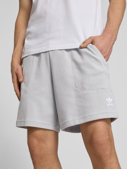 Männermodel trägt Regular Fit Sweatshorts mit Baumwoll-Anteil von adidas Originals, Optik: Unifarben, Waffelstruktur, Logo-Stitching, elastischer Bundabschluss, seitliche Eingrifftaschen, Tunnelzug innen, Nahaufnahme Oberkörper