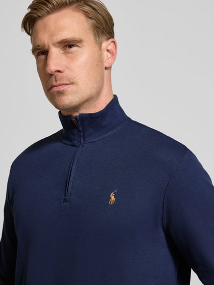 Männermodel draagt donkerblauw Sweatshirt mit Stehkragen van Polo Ralph Lauren met logo, katoenen textuur, Nahaufnahme Oberkörper.