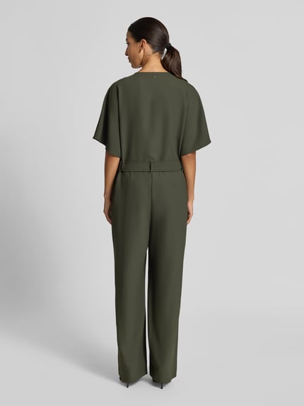 Vrouwenmodel draagt groene Jumpsuit met V-hals model 'Lehila' van MOS MOSH, halve mouw, tailleband, rechte pijpen, rugaanzicht.