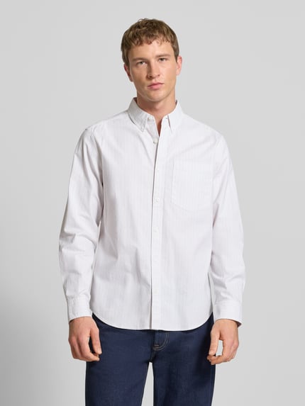 Männermodel trägt Classic Fit Freizeithemd mit Button-Down-Kragen von Calvin Klein Jeans aus weißem Baumwoll-Elasthan-Mix, Knopfleiste, Brusttasche, dezentes Label-Stitching, glatte Struktur, Ganzkörperansicht von vorne. Rückenlänge 81 cm, Schulterbreite 46 cm, Ärmellänge 65 cm bei Größe M.