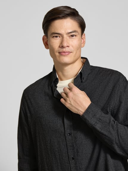 Männermodel trägt dunkelgraues Relaxed Fit Freizeithemd aus reiner Baumwolle Modell 'ARAAMO' von ARMEDANGELS, Nahaufnahme Oberkörper, Herren Freizeithemd.