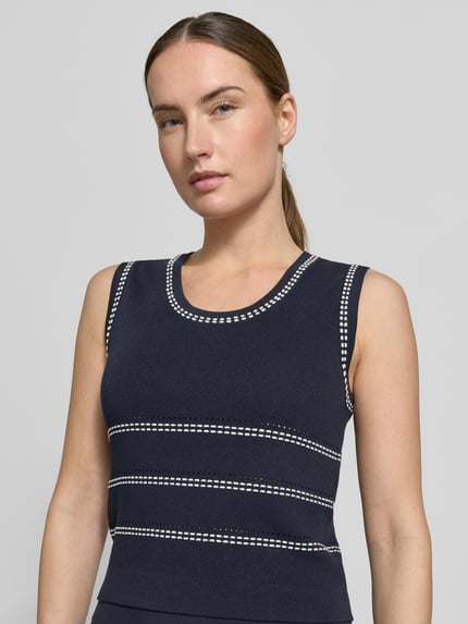 Modelka kobieca nosi top z dzianiny z mieszanki wiskozy z okrągłym dekoltem, krój slim fit, hafty, Liu Jo White, długość tyłu 47 cm, zbliżenie na górę sylwetki.