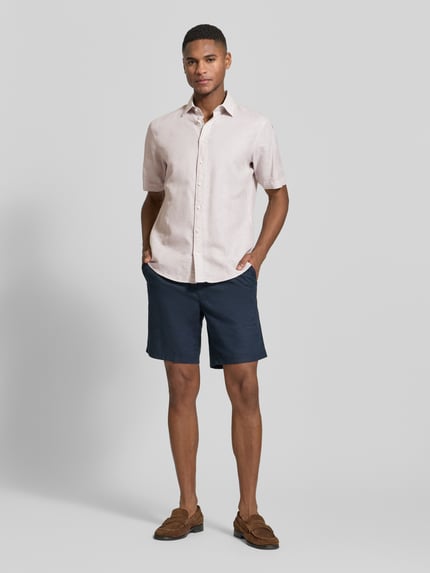 Männermodel trägt Slim Fit Freizeithemd aus Leinen-Mix von Jake*s in Beige mit Kentkragen und Knopfleiste, kurzärmelig, Ganzkörperansicht von vorne. Rückenlänge 73 cm, Schulterbreite 47 cm, Ärmellänge 26 cm.