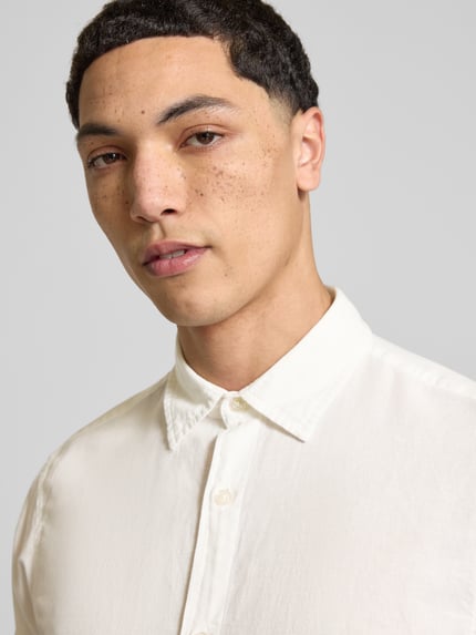 Männermodel trägt Regular Fit Freizeithemd mit Kentkragen Modell 'BREEZE' von Jack & Jones im Baumwoll-Leinen-Mix, Nahaufnahme Oberkörper.