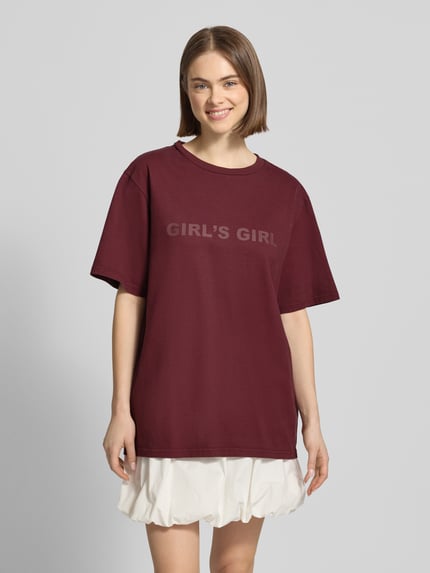 Frauenmodel trägt Oversized T-Shirt mit Statement-Print von OH APRIL in Dunkelrot, Reine Baumwolle, Oversized-Fit, Gerippter Rundhalsausschnitt, Rückenlänge bei Größe S 70 cm, Ganzkörperansicht von vorne.