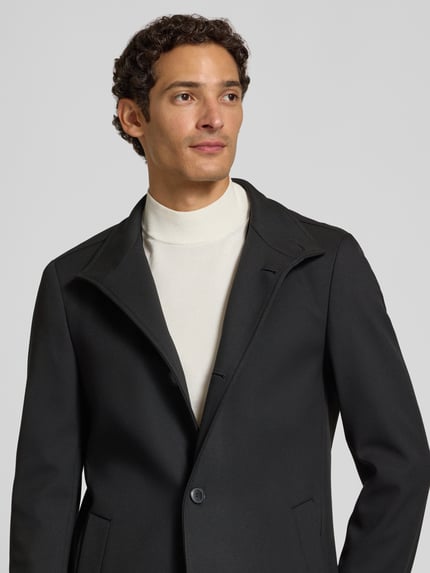 Männermodel trägt schwarzen Slim Fit Mantel mit Viskose-Anteil Modell 'H-Hyde-SU' von BOSS, Herren Mantel, Nahaufnahme Oberkörper.