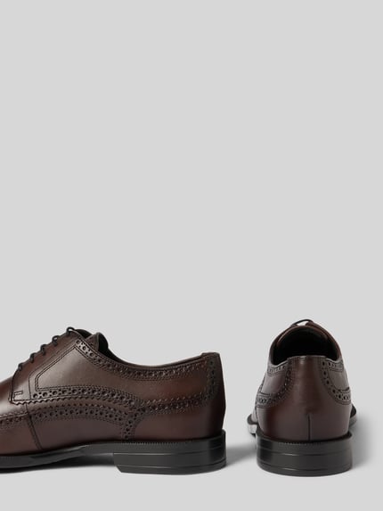 Produktfoto, braune Schnürschuhe aus echtem Leder Modell ''Tayil_Derb'' von BOSS mit Lochmuster und glatter, matter Struktur auf weißem Hintergrund.