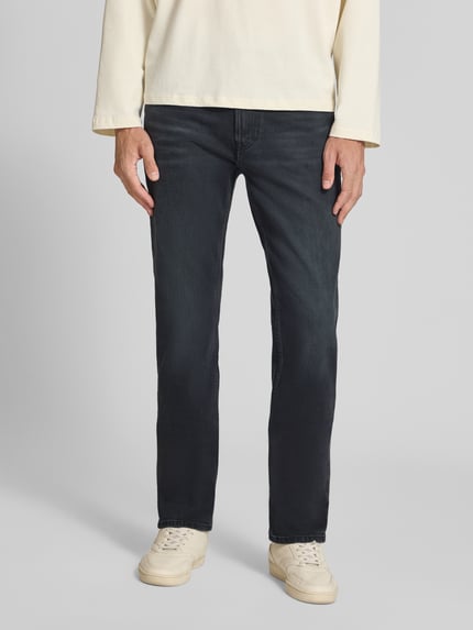 Männermodel trägt Slim Fit Jeans aus Baumwoll-Mix Modell 'MIDNIGHT EMERALD' von Calvin Klein Jeans in Dunkelblau, Ganzkörperansicht von vorne. Herren Slim Fit Jeans von Calvin Klein Jeans.