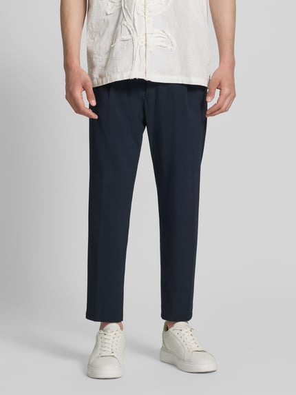 Mannenmodel draagt Hose met Gesäßtaschen Modell 'CHASY' van Drykorn in donkerblauw, slim fit, materiaalmix met katoen, binnenbeenlengte 64 cm, bandwijdte 33 cm, heren broek, voorkant, detailopname onderlichaam.