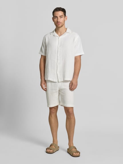 Männermodel trägt Shorts mit Eingrifftaschen und elastischem Bund von Lindbergh aus Reine Baumwolle, Loose-Fit, Ganzkörperansicht von vorne.