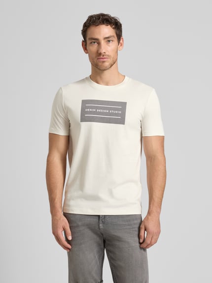 Männermodel trägt Regular Fit T-Shirt aus reiner Baumwolle von Tom Tailor Denim, unifarben, kurzer Arm, Rundhals, Label-Schriftzug, Ganzkörperansicht von vorne.