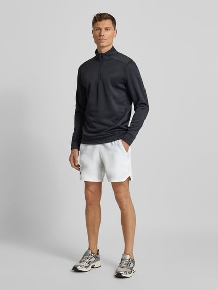 Männermodel trägt Shorts mit elastischem Bund von Under Armour, weiß, Label-Print, Französische Eingrifftaschen, Lockerer Schnitt, Ganzkörperansicht von vorne.