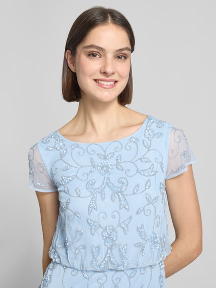 Vrouwenmodel draagt maxi-jurk met siersteentjes van Adrianna Papell in lichtblauw met bloemenmotief, met pailletten, met korte mouwen, ronde hals, ruglengte maat 36: 140 cm, borstwijdte maat 36: 39 cm, mouwlengte maat 36: 9 cm, detailopname bovenlichaam.