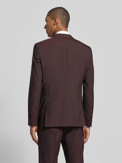 Männermodel trägt Slim Fit Sakko aus Schurwolle mit Logo-Detail von HUGO in Dunkelrot, feines Webmuster, Ganzkörperansicht Rückansicht.