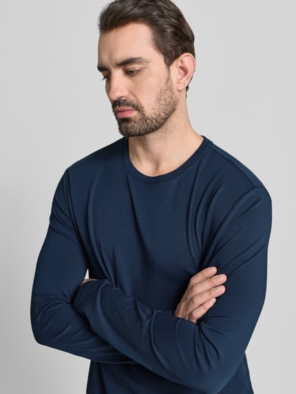 Männermodel trägt Longsleeve mit geripptem Rundhalsausschnitt von Christian Berg Men, Baumwoll-Mix, Regular Fit, Nahaufnahme Oberkörper.