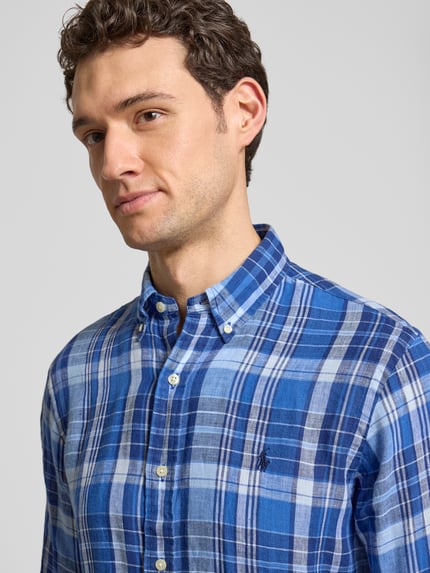 Männermodel trägt Regular Fit Freizeithemd aus reinem Leinen von Polo Ralph Lauren, blau kariert, Logo-Stitching, Nahaufnahme Oberkörper.