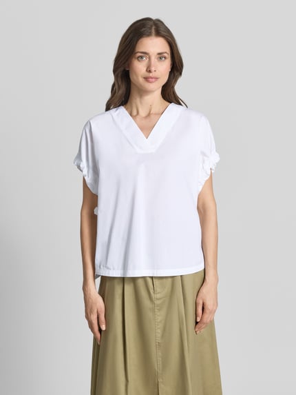 Kobiece model prezentuje Relaxed Fit Bluse mit V-Ausschnitt von Marc Cain z bawełny, krój relaxed fit, marszczenia, bluzka z krótkim rękawem, długość tyłu 59 cm, długość rękawów 5 cm, przód w całości