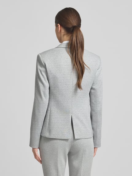 Frauenmodel trägt Shaped Fit Blazer mit Allover-Muster Modell 'JIA13A' von BOSS, Reverskragen, Rückenschlitz, Pattentaschen, Ganzkörperansicht Rückansicht.