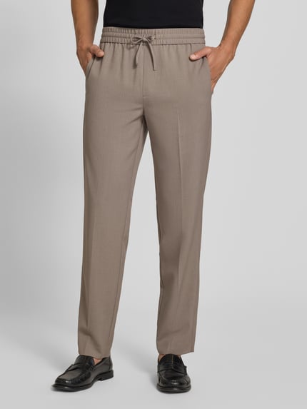 Männermodel trägt Relaxed Fit Sweatpants mit Viskose-Anteil von Lindbergh, Elastischer-Material-Mix, Bügelfalten, Ganzkörperansicht von vorne.