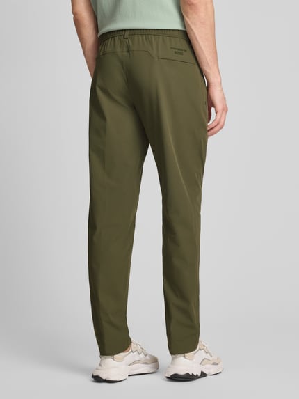 Männermodel trägt Regular Fit Hose mit Bügelfalten Modell 'PS SPIRIT70' von BOSS Green, Optik: Unifarben, Ganzkörperansicht Rückansicht.
