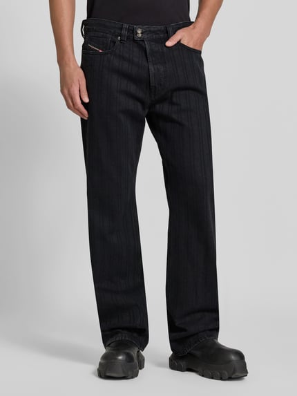 Männermodel trägt Straight Fit Jeans mit Viskose-Anteil von Diesel, Baumwoll-Mix, 5-Pocket, schwarz, Logo-Detail, Nahaufnahme Oberkörper.