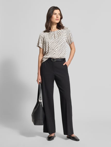 Vrouwenmodel draagt Blusenshirt mit Schlüsselloch-Ausschnitt van comma, materiaalmix met stretch, regular fit, allover-look, plooien, korte mouw, sleutelgat-hals, zwart-wit, voorkant, volledige lichaamsweergave