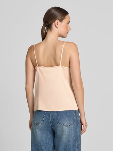 Kobiece modelka ma na sobie Blusentop mit Spitzenbesatz Model 'GIONA' od DRYKORN, Mieszanka materiałów z dodatkiem streczu, krój regular fit, cienkie ramiączka, dekolt w serek, długość tyłu w rozmiarze 36: 33 cm, widok całej sylwetki z tyłu.