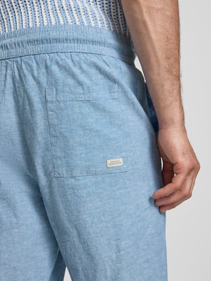 Männermodel trägt Hose aus Baumwoll-Leinen-Mix mit elastischem Bund von Blend in Hellblau, Struktur sichtbar, Nahaufnahme Rückansicht. Regular Fit, Modell 'ABAN', Bundweite 39 cm, Innenbeinlänge 76 cm.