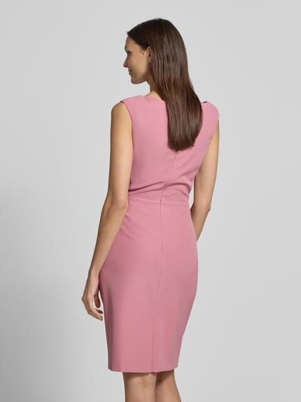 Modelka nosi Knielanges Cocktailkleid mit Raffungen von Vera Mont w różowym kolorze, prosty materiał z elastycznym dodatkiem, długość do kolan, widoczne marszczenia, szerokość w rozmiarze 36: 42 cm, długość na plecach w rozmiarze 36: 99 cm, widok całej sylwetki od tyłu.