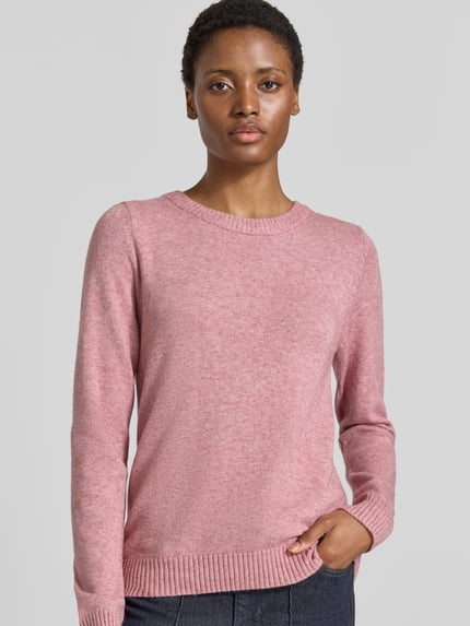 Frauenmodel trägt Strickpullover aus Viskose-Mix von VILA in Rosa, taillierte Passform, gerippter Rundhalsausschnitt, Nahaufnahme Oberkörper.