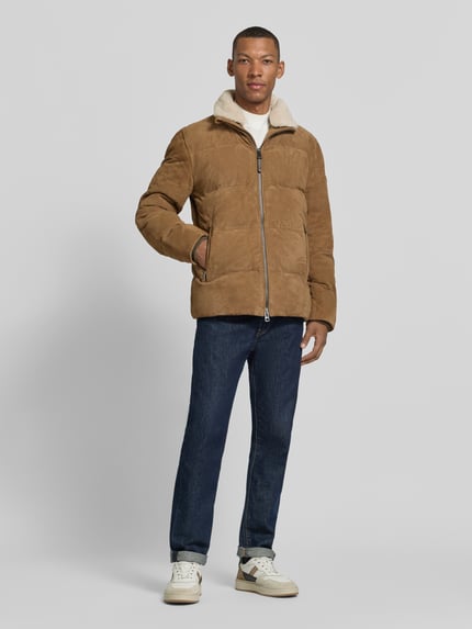 Männermodel trägt Lederjacke aus Ziegenvelours Modell 'Dorin' von JOOP!, unifarben, Stehkragen, Zweiwege-Reißverschluss, Taschen, Jeans, Ganzkörperansicht von vorne