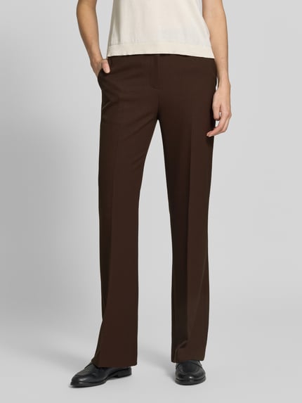 Kobiece model prezentuje Slim Fit Schmale Hose mit Viskose-Anteil od GANT, spodnie materiałowe o efekcie jednolity kolor, z Kantami, wpuszczane kieszenie i kieszeń z tyłu, średni stan, zapięcie na guzik i zamek błyskawiczny, wykończenie twill, dodatek wiskozy, widok całej sylwetki z przodu.