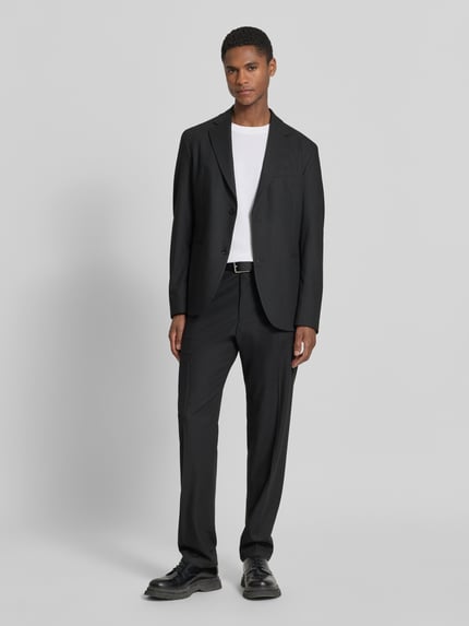 Männermodel trägt Anzughose mit Bügelfalten Modell 'AJEND' von Drykorn in Schwarz, Regular Fit, Material-Mix, Ganzkörperansicht von vorne.