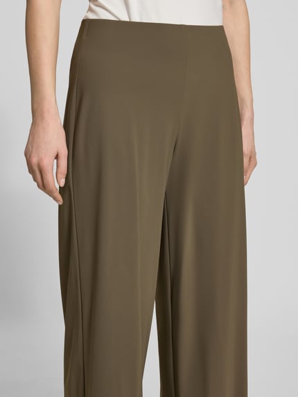 Frauenmodel trägt Relaxed Fit Schlupfhose Modell 'SALLY' von Raffaello Rossi aus olivgrünem High-Tech-Jersey, elastischer Bund, Detailaufnahme. Bundweite bei Größe 36: 39 cm, Innenbeinlänge bei Größe 36: 68 cm.