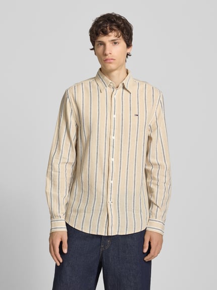 Männermodel trägt Regular Fit Freizeithemd aus Leinen-Baumwoll-Mix von Tommy Jeans, Mehrfarbig, Gestreift, Logo-Schriftzug, Ganzkörperansicht von vorne.