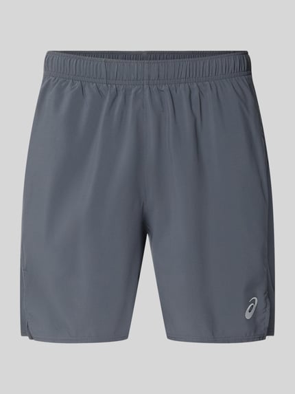 Produktfoto, graue Regular Fit Shorts mit integriertem Slip Modell 'Core' von ASICS TIGER, Logo-Print, elastischer Bund, glatte Textur.