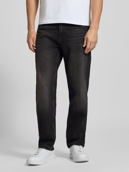 Männermodel trägt Jeans aus reiner Baumwolle mit Fading-Effekten Modell „Atakamo“ von BOSS Orange, dunkler Denim, lockerer Schnitt, Ganzkörperansicht von vorne.