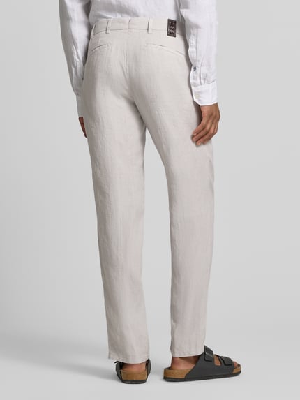 Mężczyznamodel nosi Straight Fit Leinenhose aus reinen Leinen Modell 'Lynx' von Mmx w kolorze jasnoszarym, kieszenie z tyłu, zapięcie na guzik i zamek błyskawiczny, szerokość w rozmiarze 32/32: 43 cm, długość wewnętrzna nogawki: 81 cm, widok całej sylwetki z tyłu.