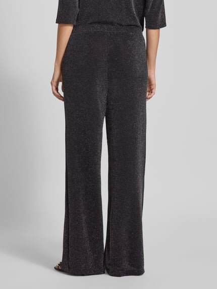Frauenmodel trägt Stoffhose mit Glitter-Effekt von Christian Berg Woman in Schwarz, Material-Mix mit Stretch-Anteil, Lockerer-Schnitt, elastischer Bund, Ganzkörperansicht Rückansicht.