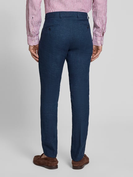 Männermodel trägt Leinenhose mit französischen Eingrifftaschen Modell 'Tomte' von Carl Gross in Dunkelblau, reine Leinenstruktur, Ganzkörperansicht Rückansicht.