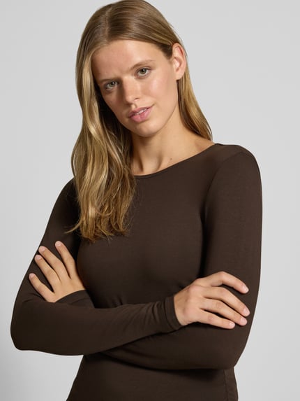 Frauenmodel trägt Regular Fit Langarmshirt aus Baumwoll-Mix Modell 'MIRA' von ONLY, dunkelbraun, glatte Textur, Nahaufnahme Oberkörper, Damen Langarmshirt von ONLY.
