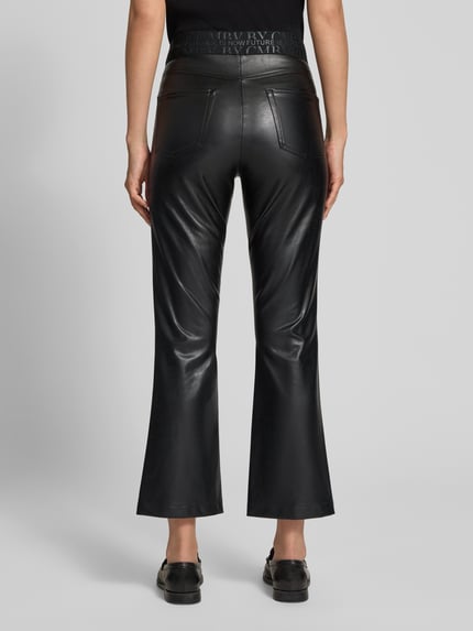 Frauenmodel trägt schwarze Slim Fit Kunstlederhose in Glattleder-Optik Modell 'FELICE' von CAMBIO, Ganzkörperansicht Rückansicht. Damen Leder- / Kunstlederhose.