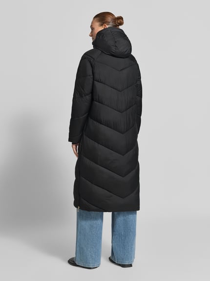 Frauenmodel trägt schwarzen Relaxed Fit Steppmantel mit Kapuze von JOOP! vor grauem Hintergrund, Ganzkörperansicht Rückansicht. Damen Steppmantel von JOOP!