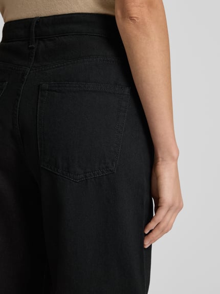 Frauenmodel trägt Barrel Jeans mit 5-Pocket-Design Modell 'CAROL' von Mango aus reiner Baumwolle, schwarze Farbe, Detailaufnahme Rückansicht